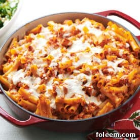 Chicken Parmesan Baked Ziti in red pan on table.