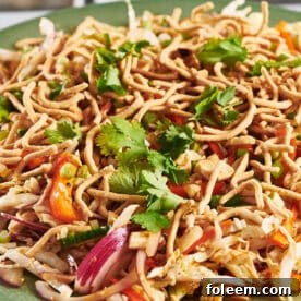 Chinese chicken salad piled on green plate.