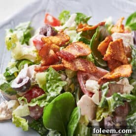 Chopped salad with chicken and blue cheese on white plate.