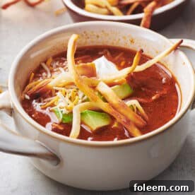 Mexican Tortilla Chicken Soup in white bowl on table.