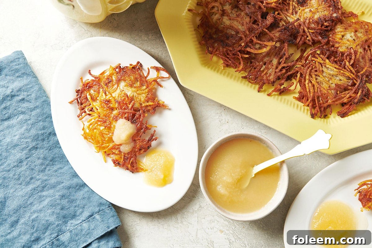 Potato pancakes on plate and platter with apple sauce