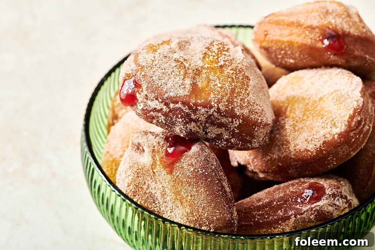 Pile of Jelly Doughnuts in a green bowl.