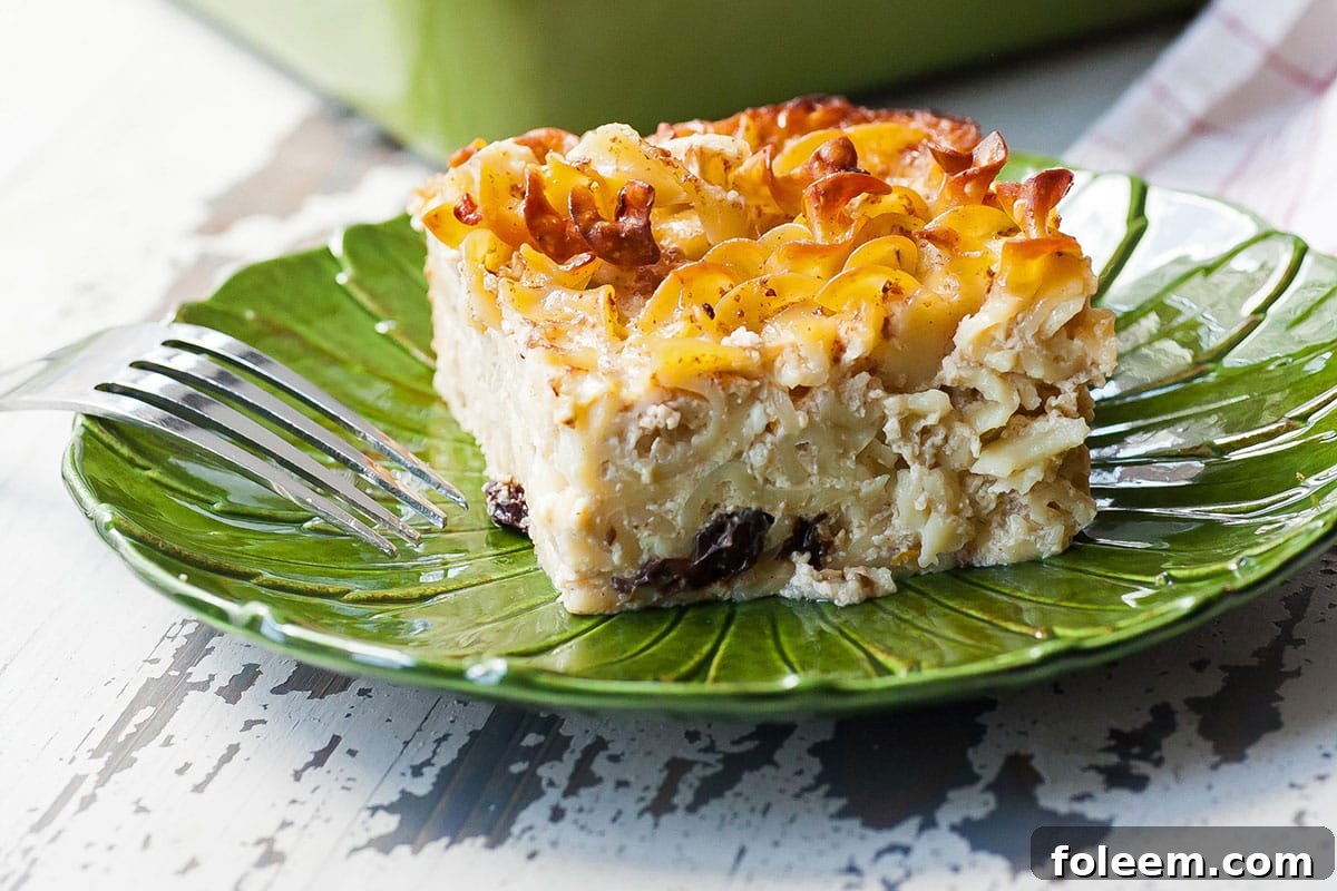 Slice of Jewish Noodle Kugel on green plate with fork.