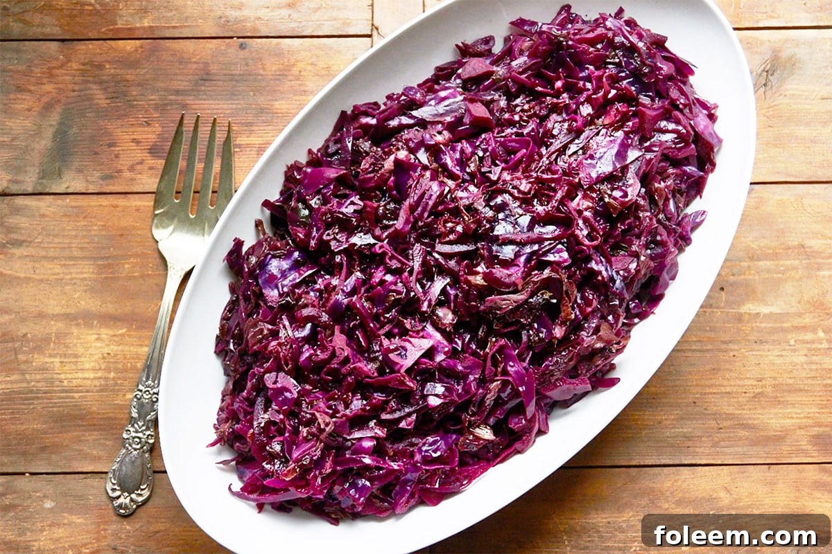 Braised red cabbage in large white serving dish on table.