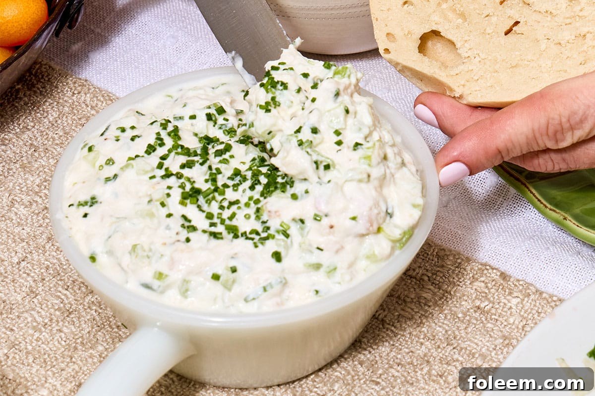 Whitefish salad with chopped chives in bowl on table.