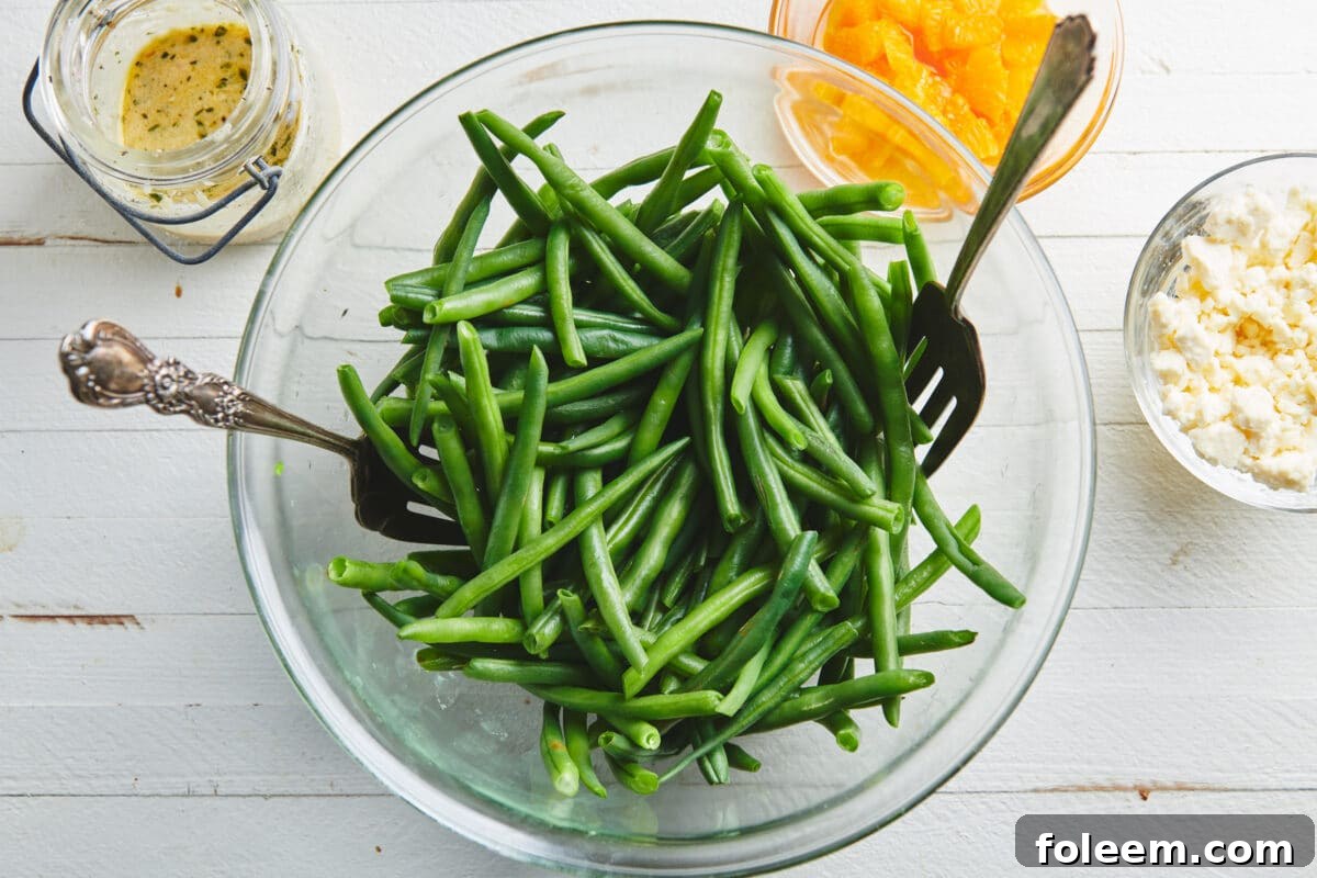 Blanched green beans in large glass bowl on table.