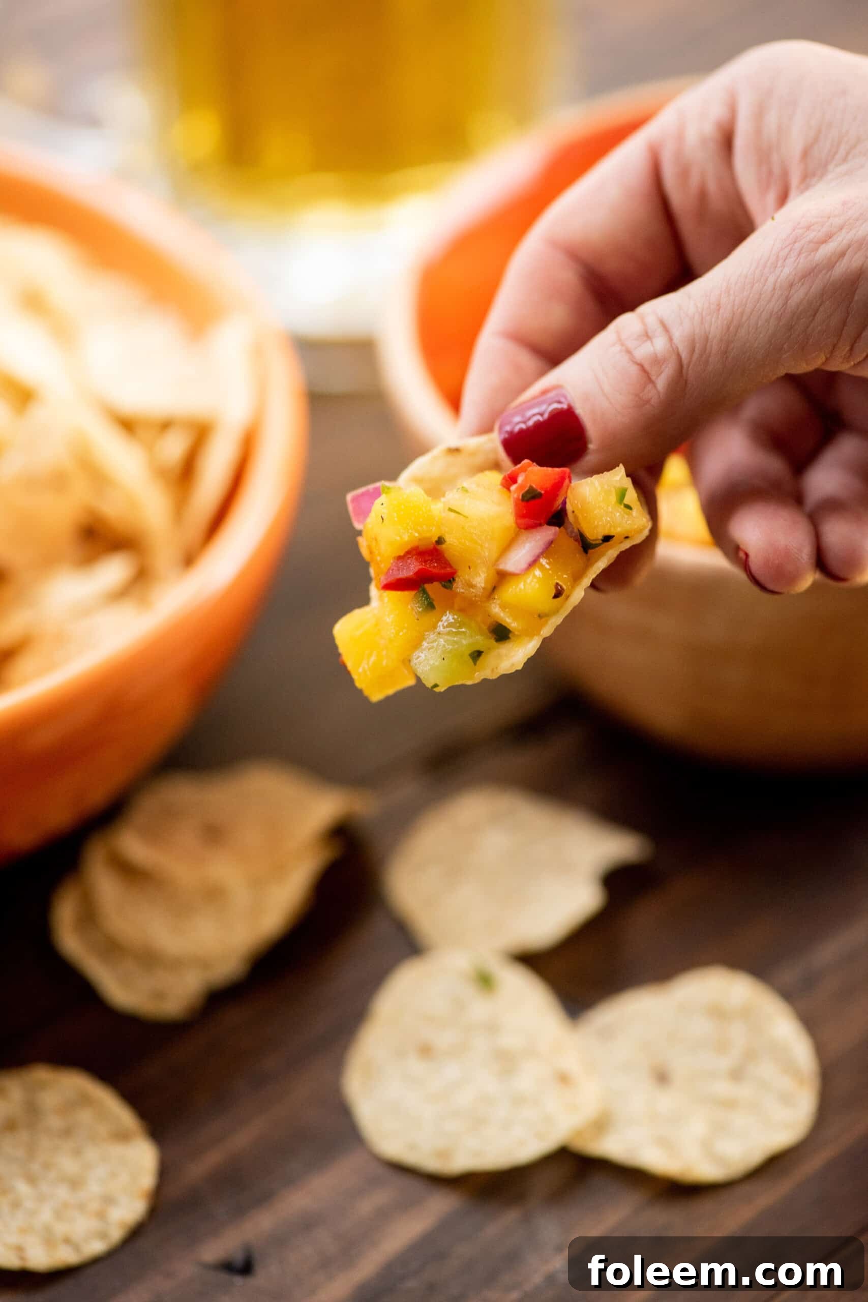 Scooping Tropical Fruit Salsa with tortilla chips.