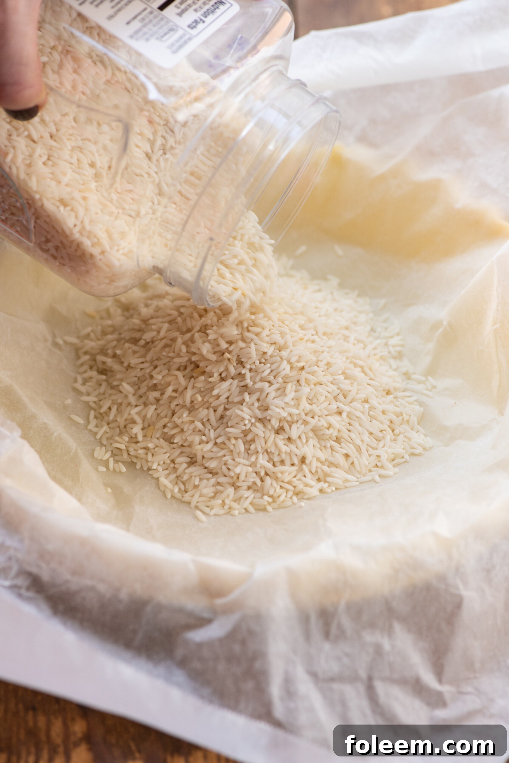 Rice pouring into a pie crust covered in parchment paper.
