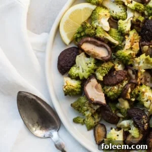 Roasted Broccoflower and Shiitake Mushrooms with Rosemary and Garlic on white plate.