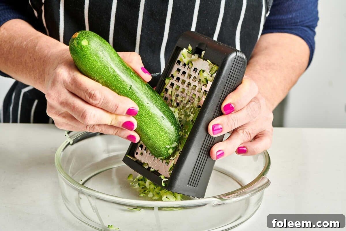 Shredding fresh Zucchini with box grater.