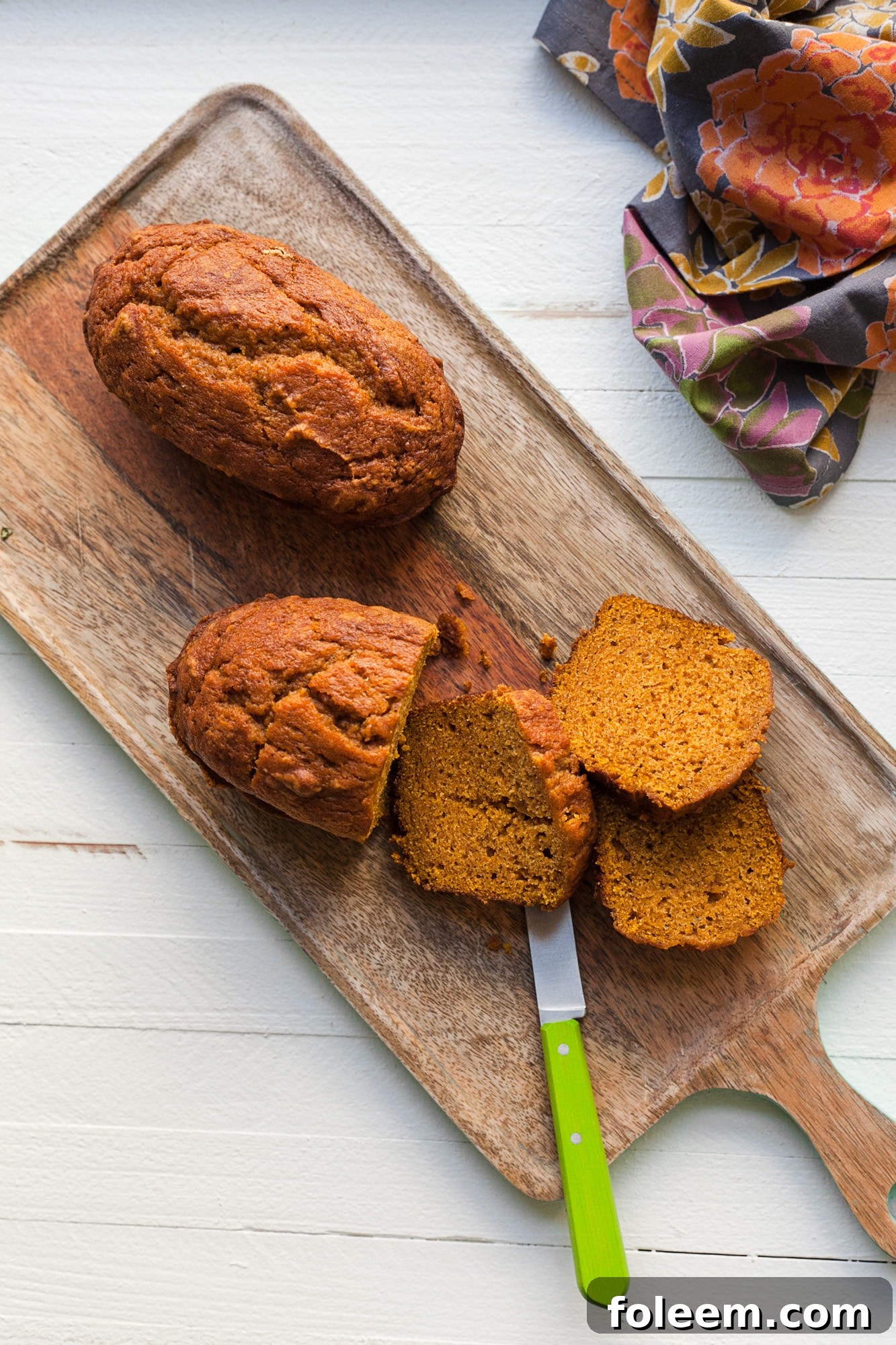 Pumpkin bread on a cutting board with a few cut slices.