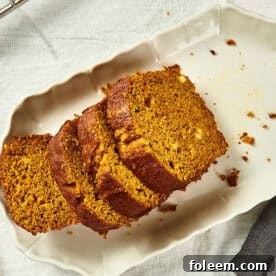 Sliced pumpkin bread on white plate.