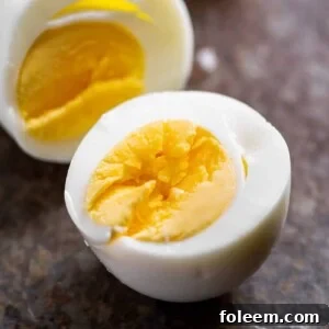 Split hard-boiled egg on stone surface.