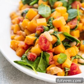 Butternut Squash and White Bean Ragout piled on a white dish.