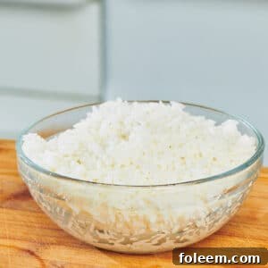 Cooked rice in glass bowl on counter.