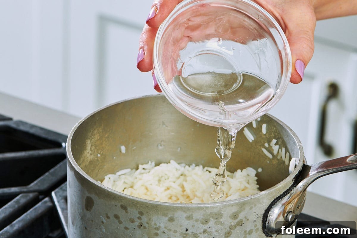 Pouring water into pot of leftover cooked rice.