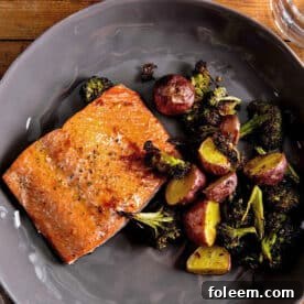 Baked salmon, potatoes, and broccoli on plate.