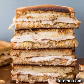 Stack of turkey Reuben sandwiches on cutting board.
