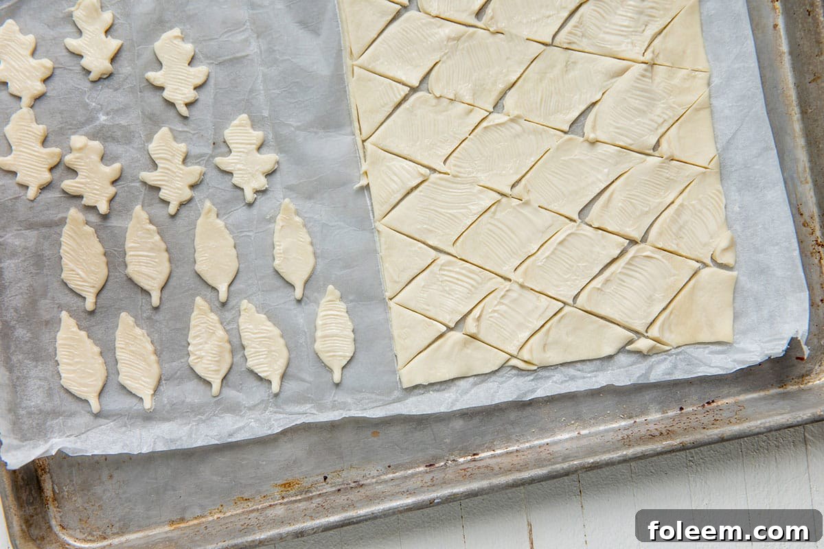 Leaf and diamond shaped puff pastry on baking sheet.