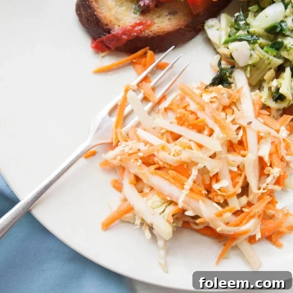 Carrot, Cabbage and Kohlrabi Slaw on plate with other dishes.