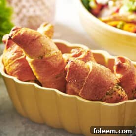 Pesto-filled crescent rolls in yellow serving dish on table.