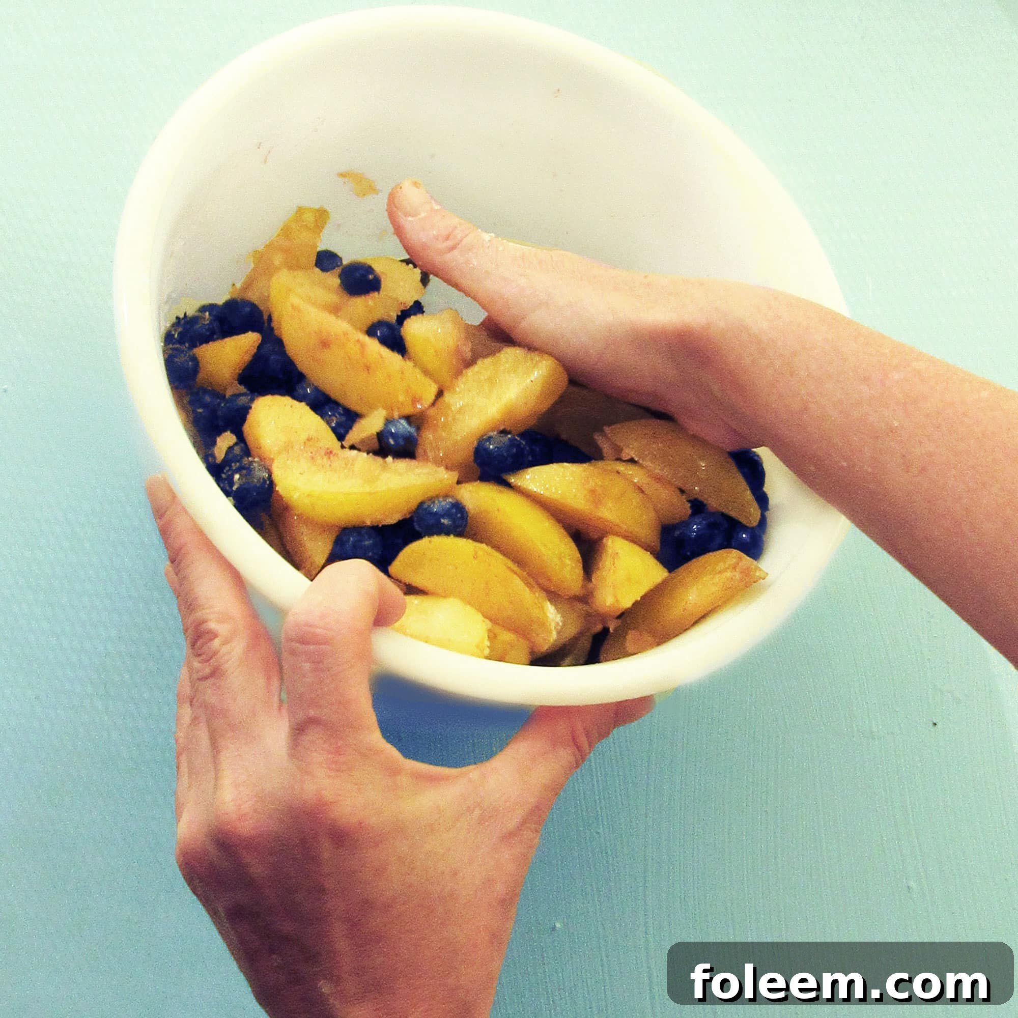 Tossing fruit with the sugar and spices for a galette or crostata.