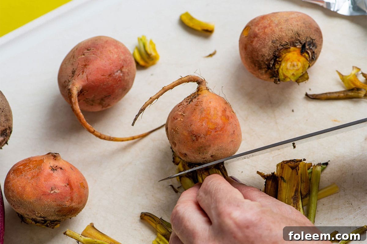 Cutting fresh yellow striped beets on cutting board with knife.