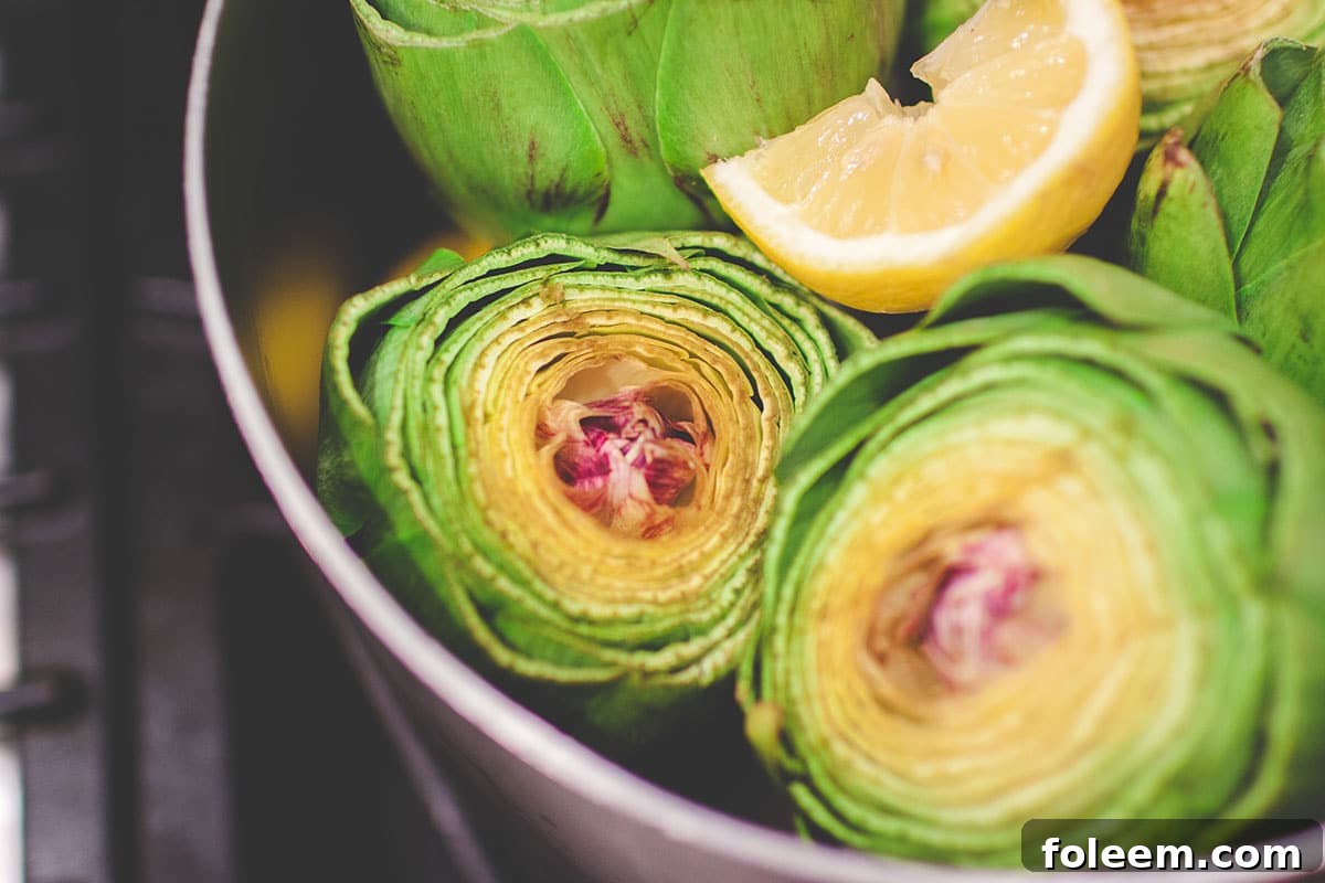 Pot filled with steamed artichokes.