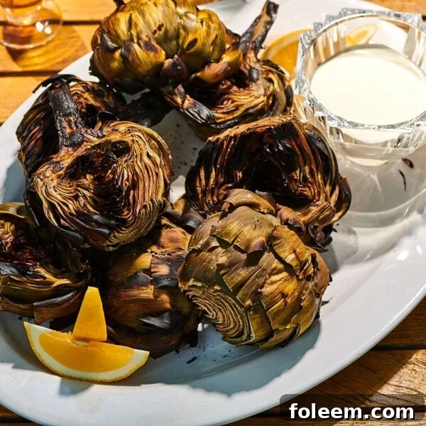 Grilled Artichokes with lemon sauce on plate.
