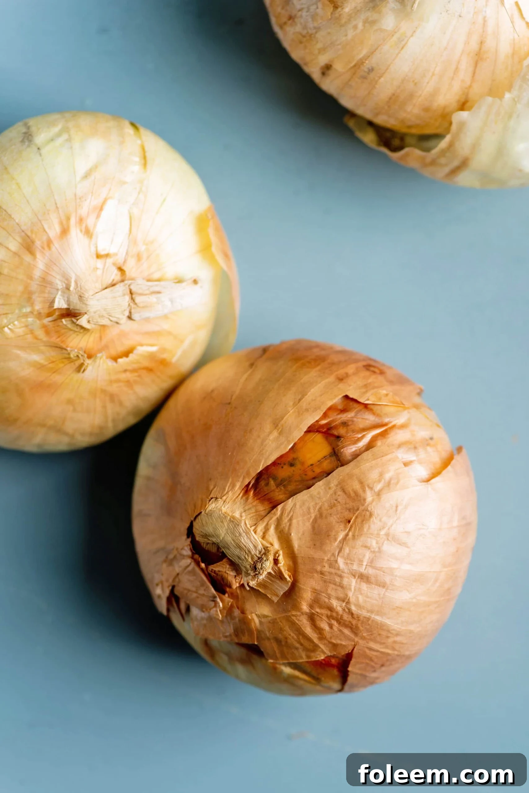 Blue table with three Vidalia Onions.