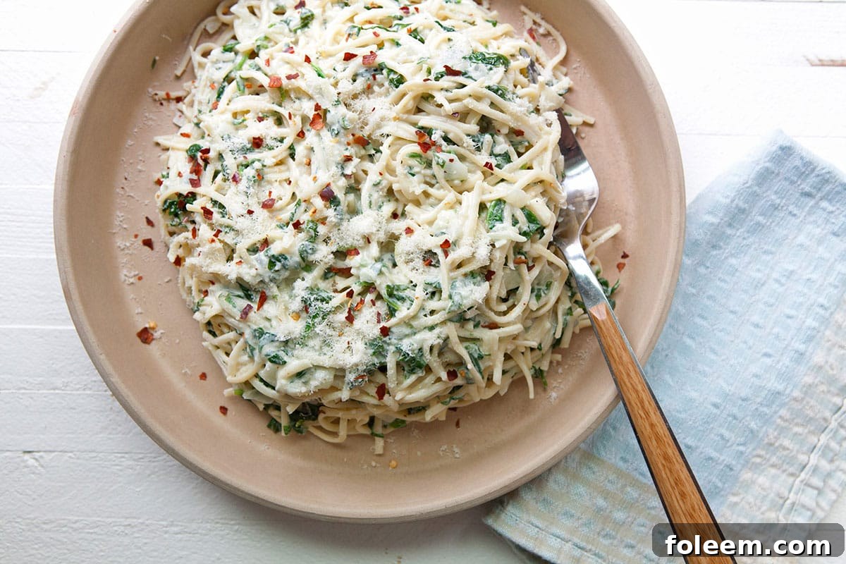 Creamy Goat Cheese and Spinach Linguine on brown plate.