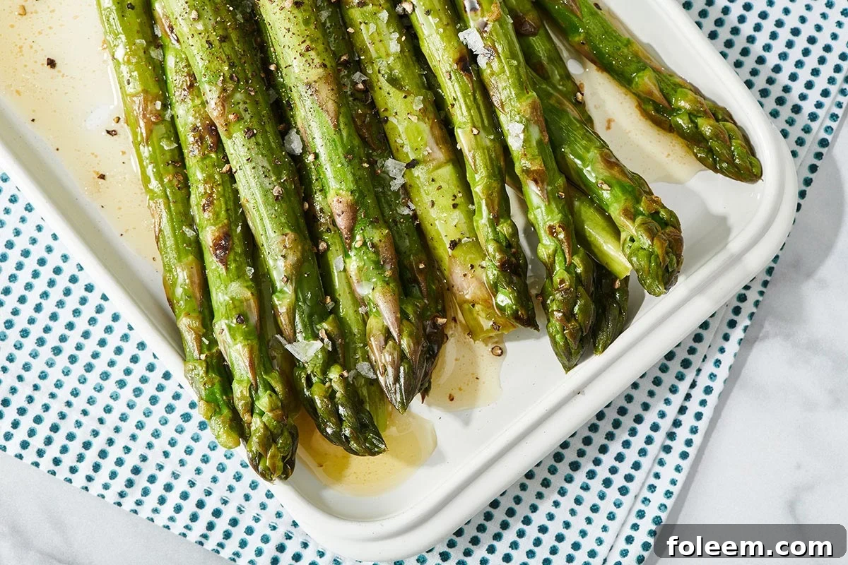 Grilled asparagus in lemon butter sauce on platter