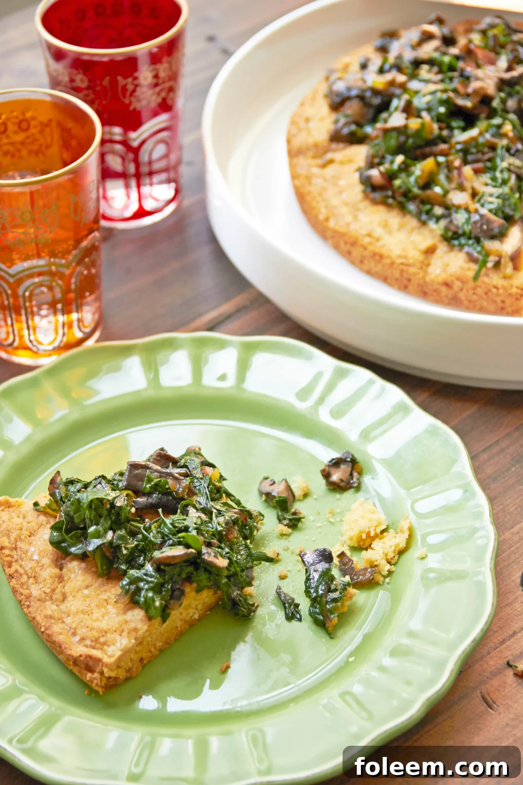 Big Biscuit with Swiss Chard and Mushrooms on green plate with drink glasses.
