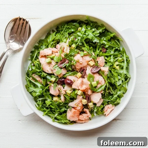 Salmon, Arugula, and Avocado Salad with Lemon Vinaigrette in serving dish.