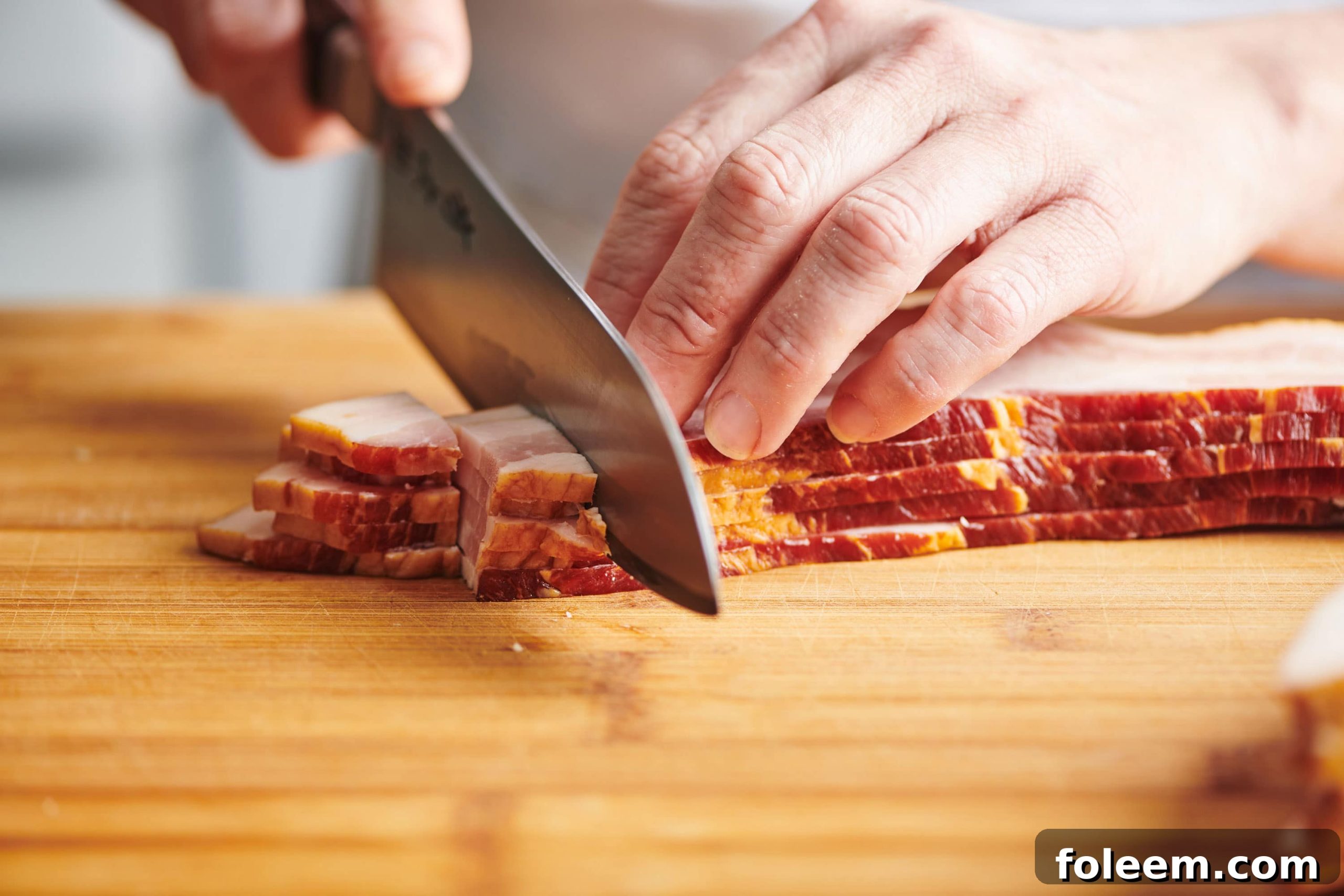 Chopping bacon into lardons with chef knife.