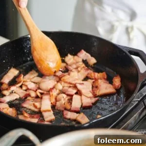 Cooking bacon in pan on stove.