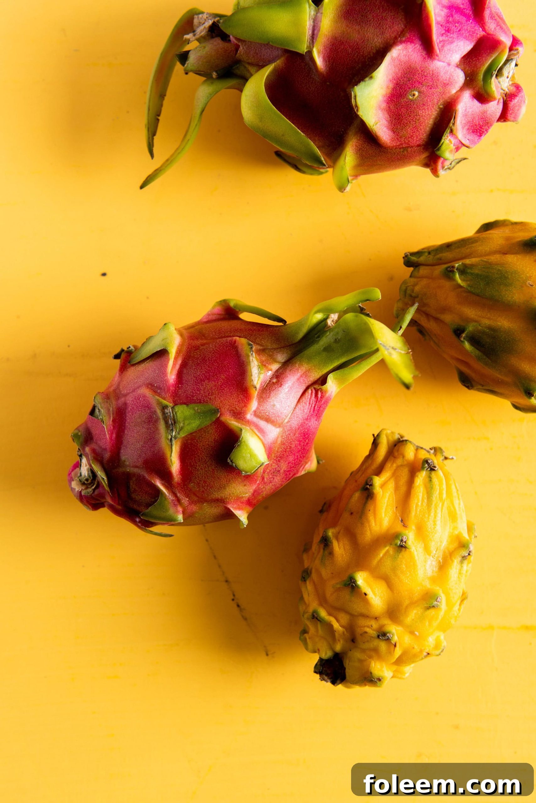 Fresh dragon fruit on white surface.