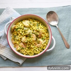 Spoon next to a bowl of Shrimp and Corn Salad with Basil Dressing.