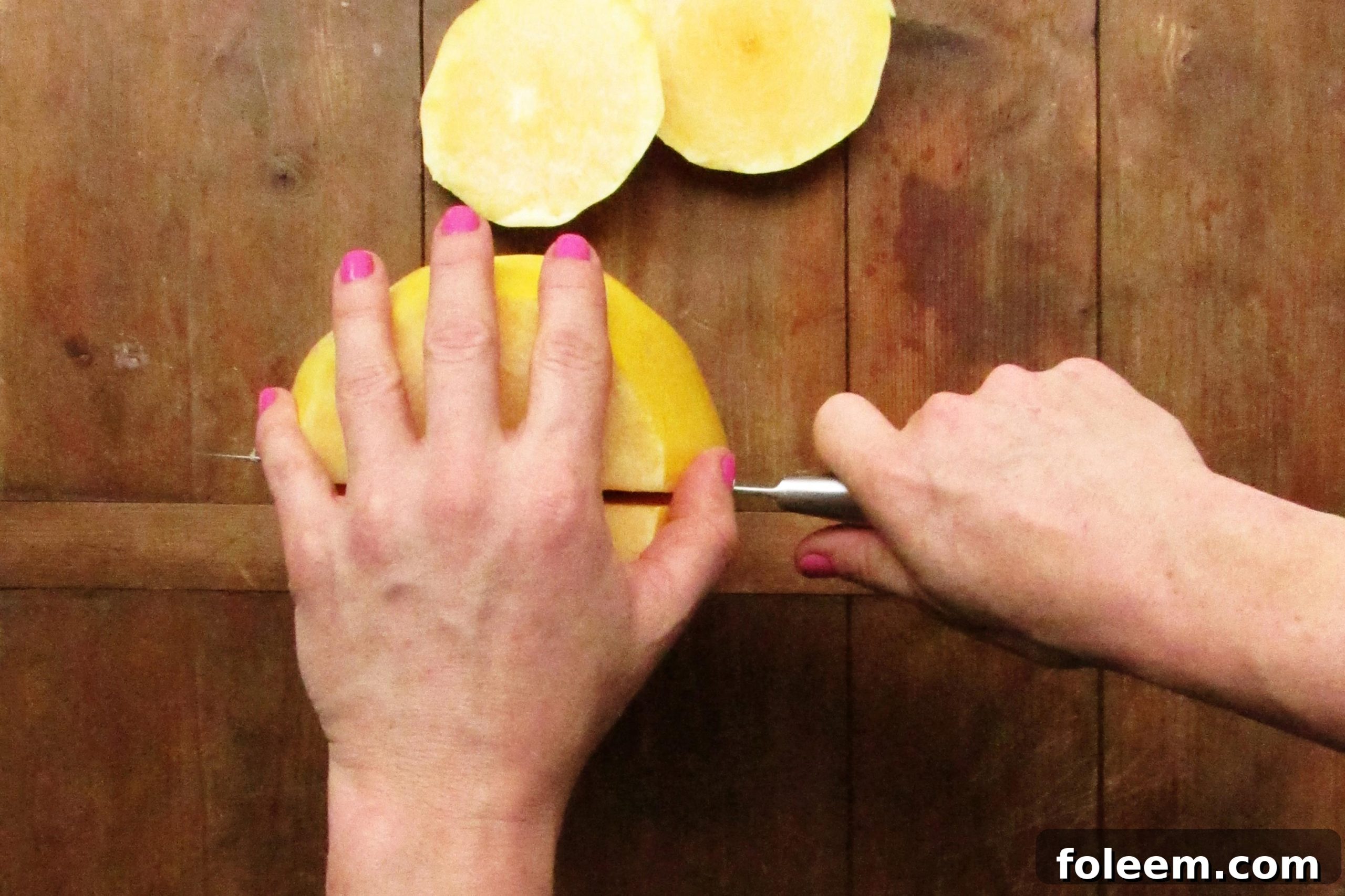 Woman cutting a spaghetti squash in half the long way.
