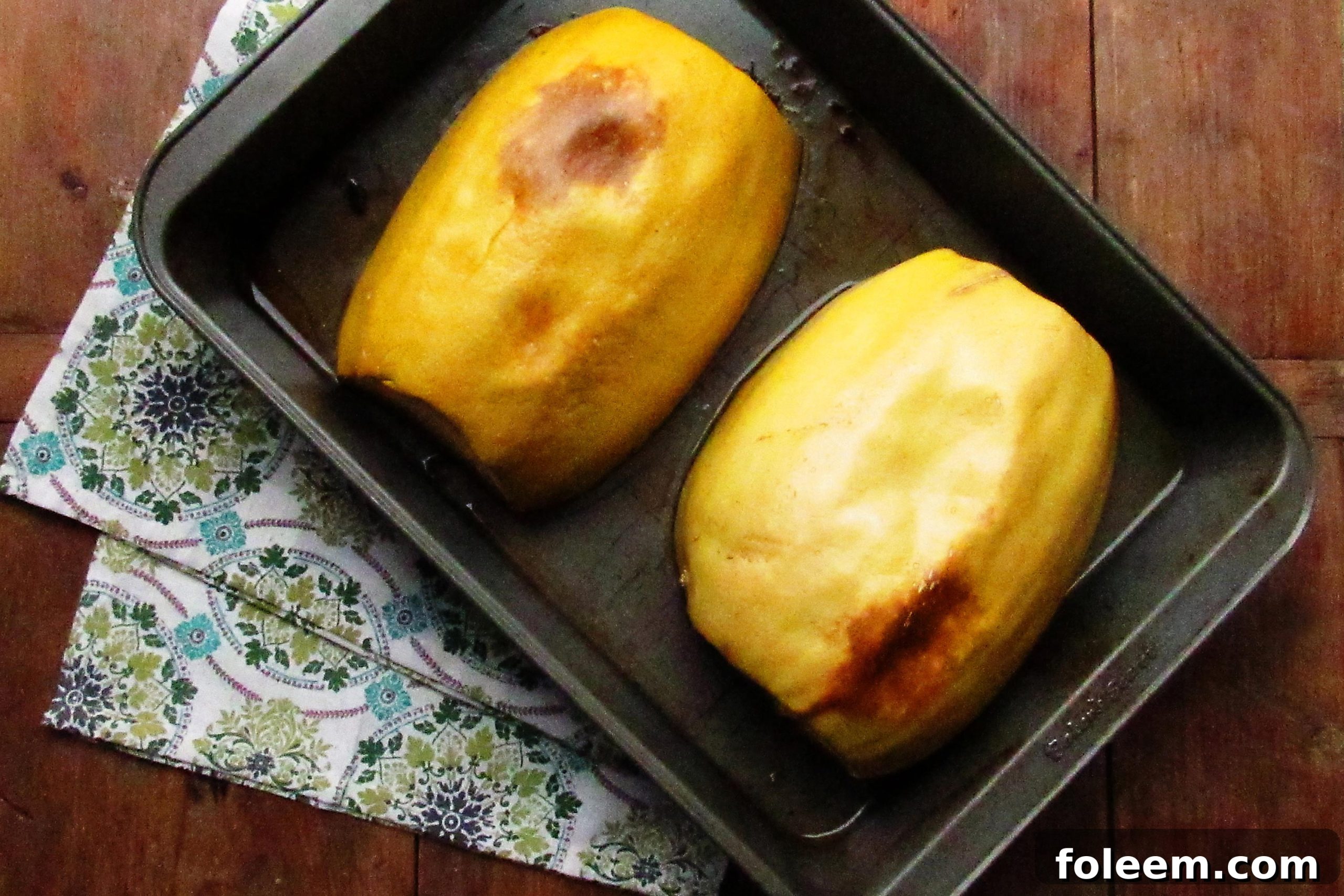 Two spaghetti squash halves in a baking dish.