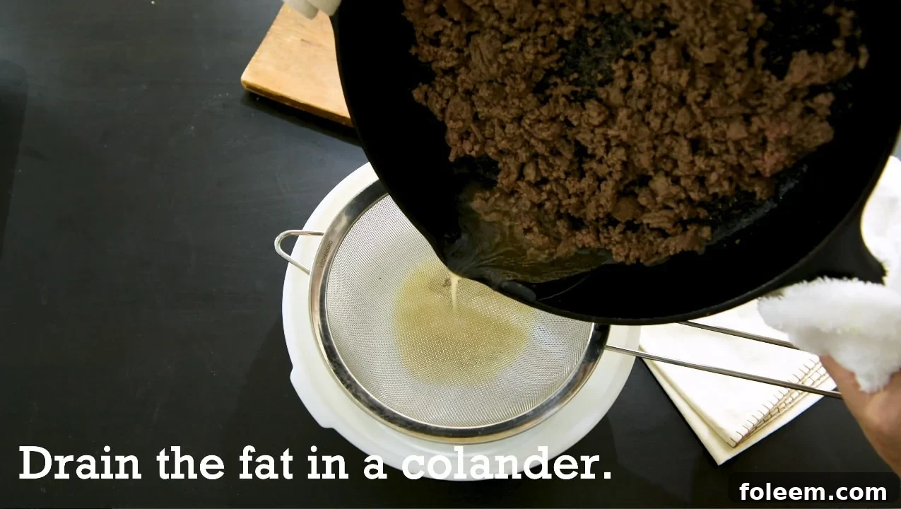 Draining fat from ground beef into a colander.