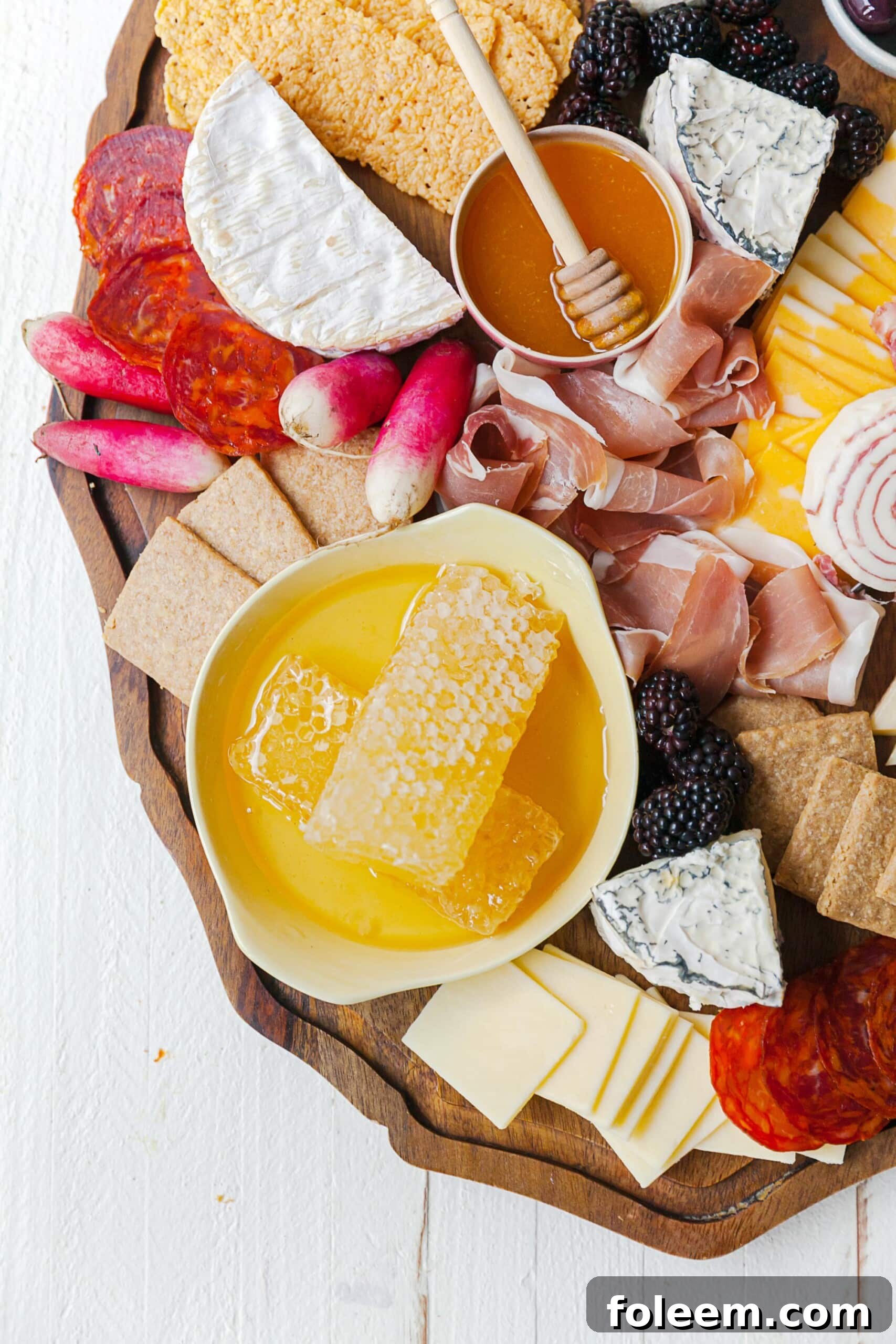Honeycombs in a bowl on a grazing board.