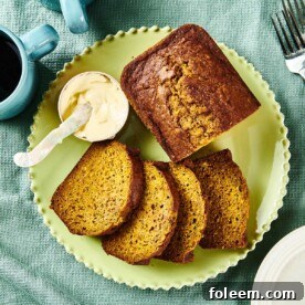 Pumpkin Zucchini Bread loaf and slices on green plate.