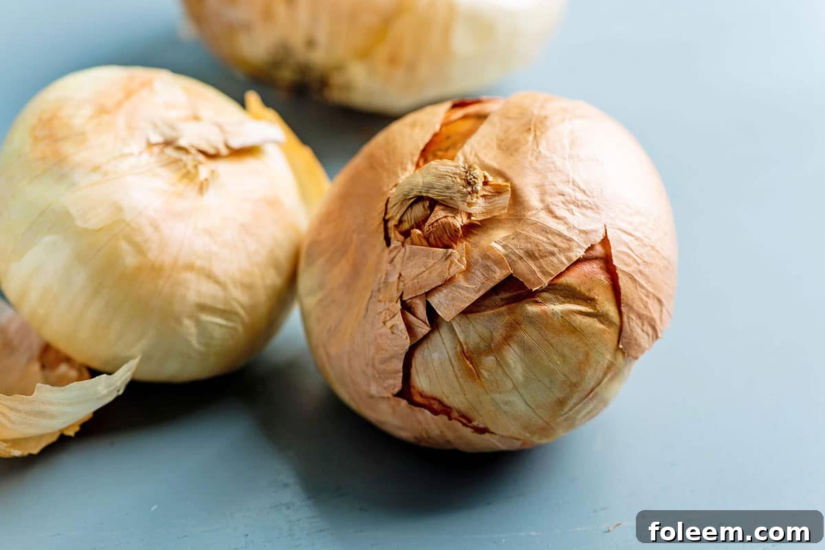 Golden Vidalia Onions sitting on a blue table.
