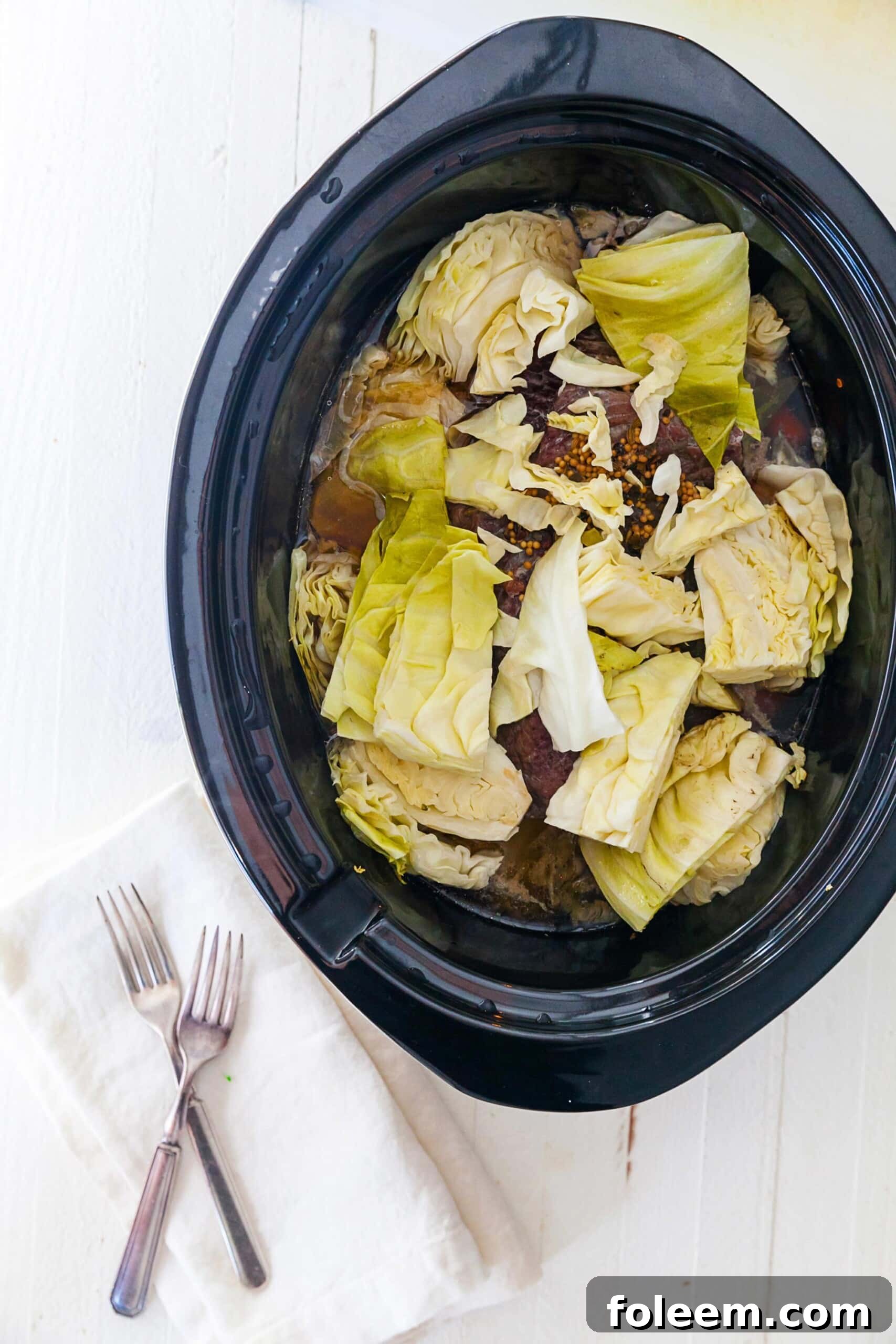 Corned Beef and raw cabbage in slow cooker.