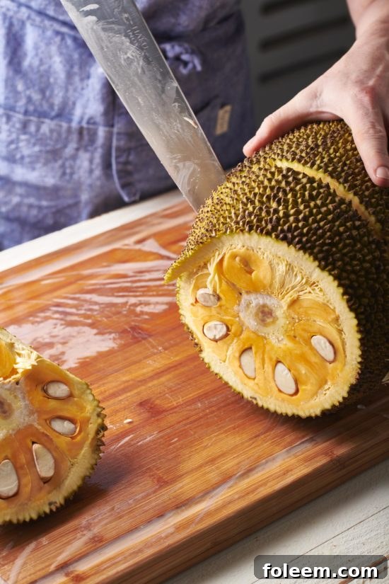 Woman slicing a jackfruit.