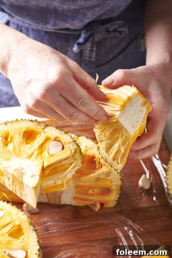 Woman holding a piece of jackfruit.