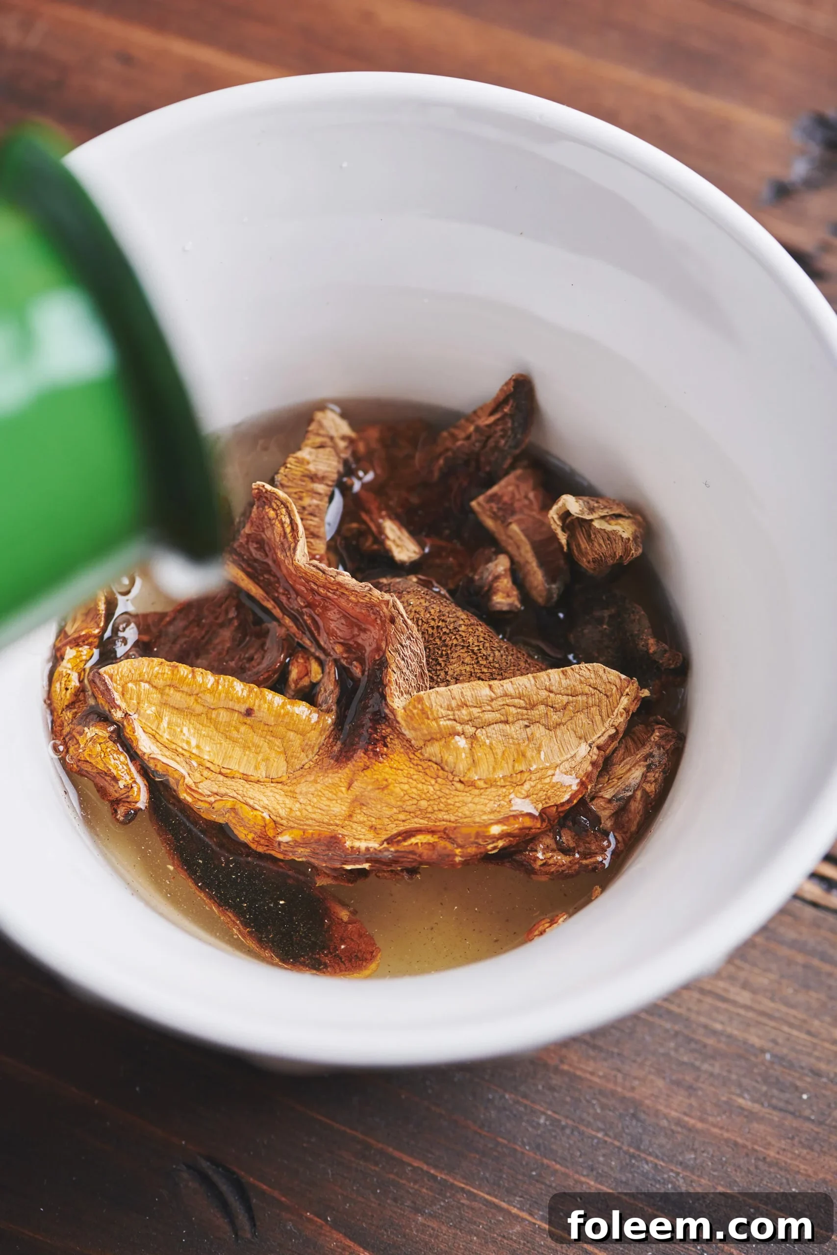 Dried mushrooms soaking in a white bowl.