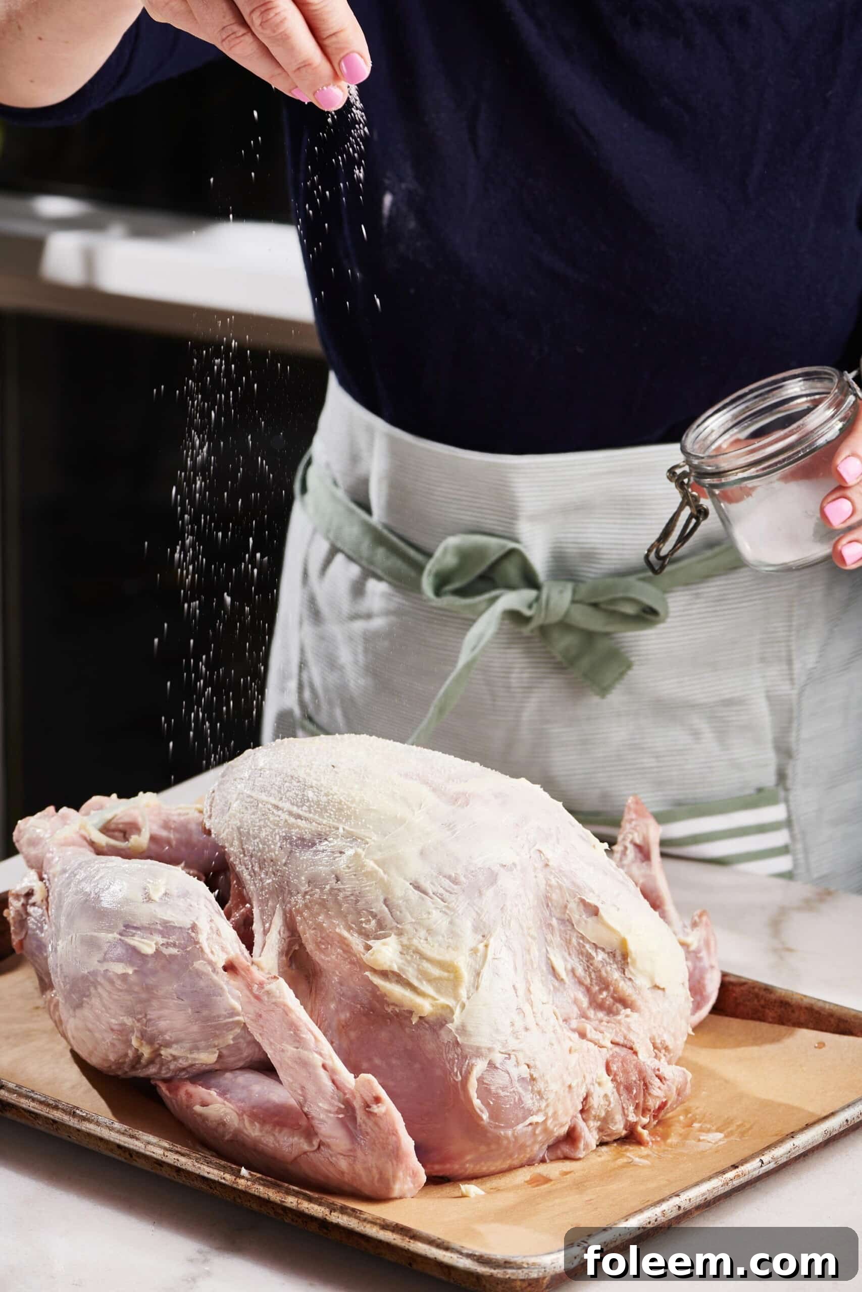 Seasoning whole turkey with salt.