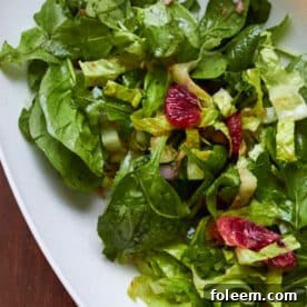 Leafy green salad in bowl with pomegranate vinaigrette.